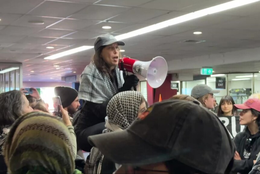 A woman holding a megaphone in a crowd of protesters