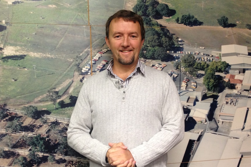 Simon Stahl in front of an aerial shot of the abattoir in Casino.