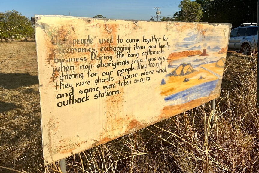 A faded yellow sign describes how Aboriginal people were taken or shot during the early days of white settlement.