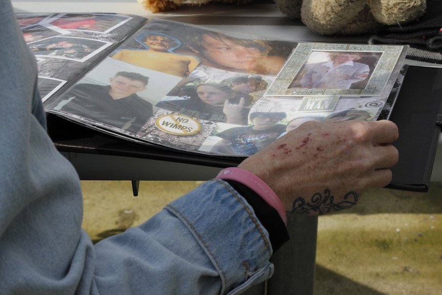 A woman's hand flicks through a photo album