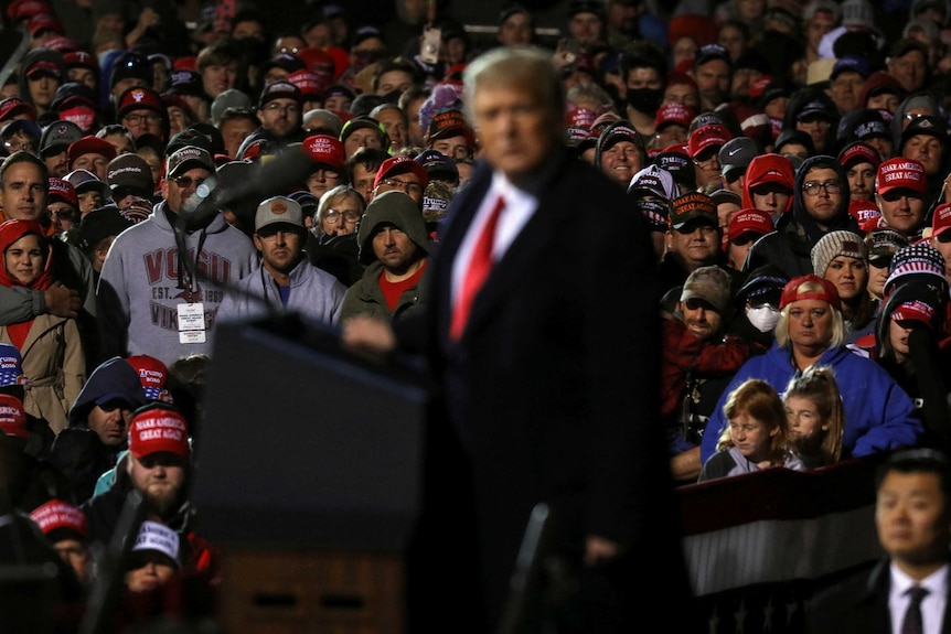 upporters of U.S. President Donald Trump look on as Trump speaks during a campaign rally