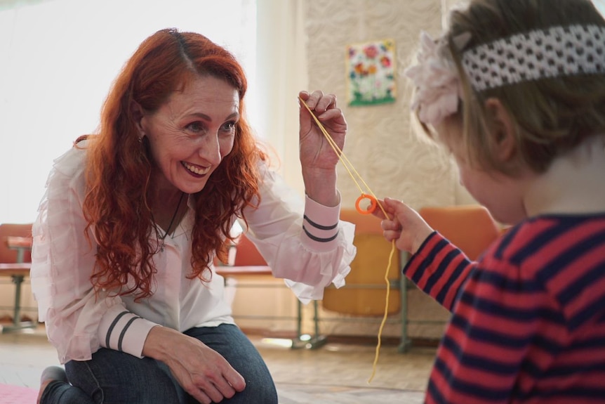 Maria plays with Bridget on the floor.