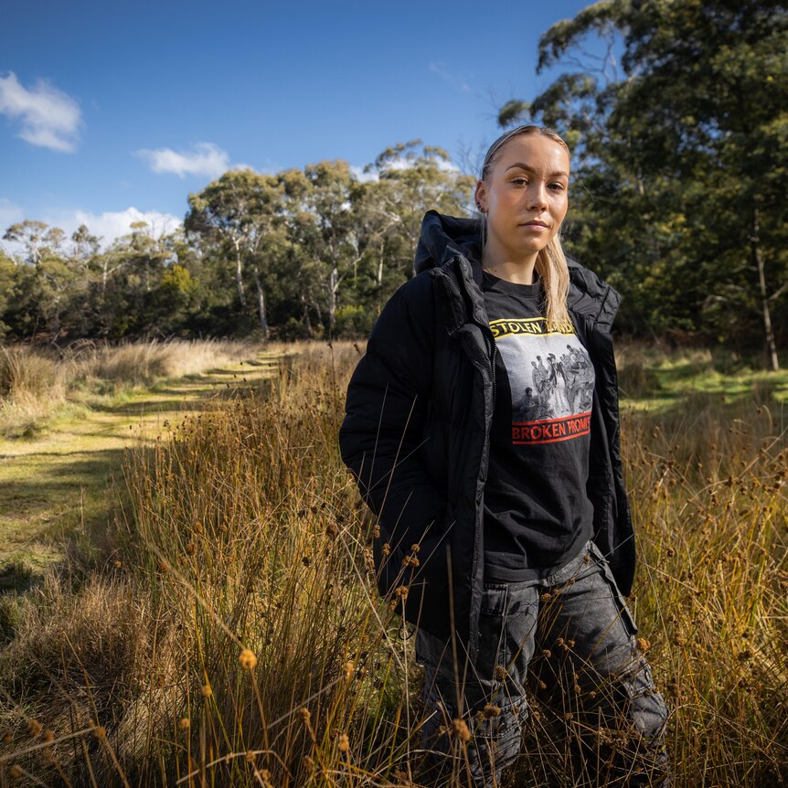 A young woman stands in a field