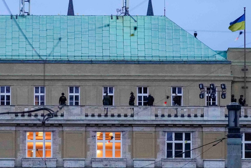 Police officers stand on the balcony of Philosophical Faculty of Charles University. 