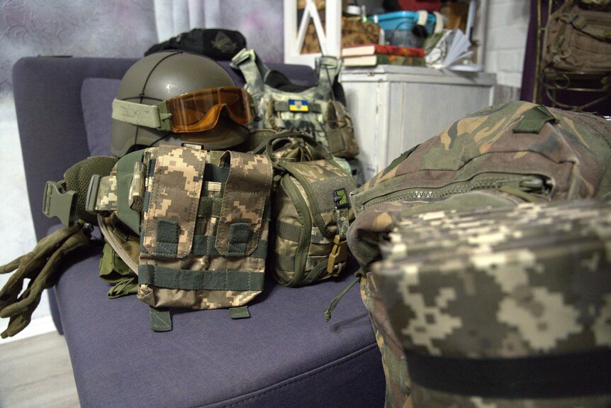 A combat helmet and camouflaged backpack.
