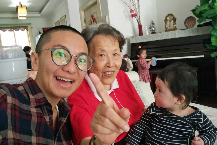 Jinghua Qian with a woman and two children in a living room.