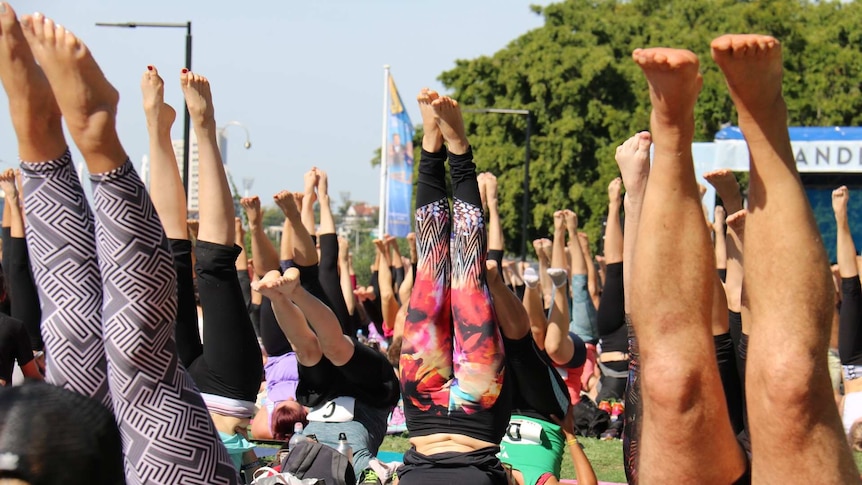 People do yoga outside.