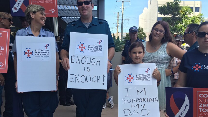 Paramedics hold signs that says enough is enough.
