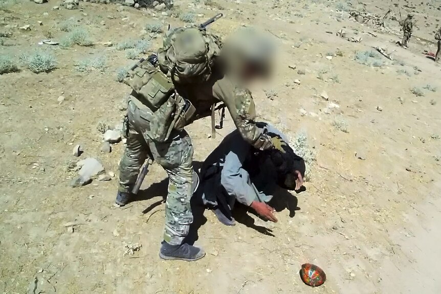 SAS Soldier holds Afghan man during 3 Squadron deployment in 2012.