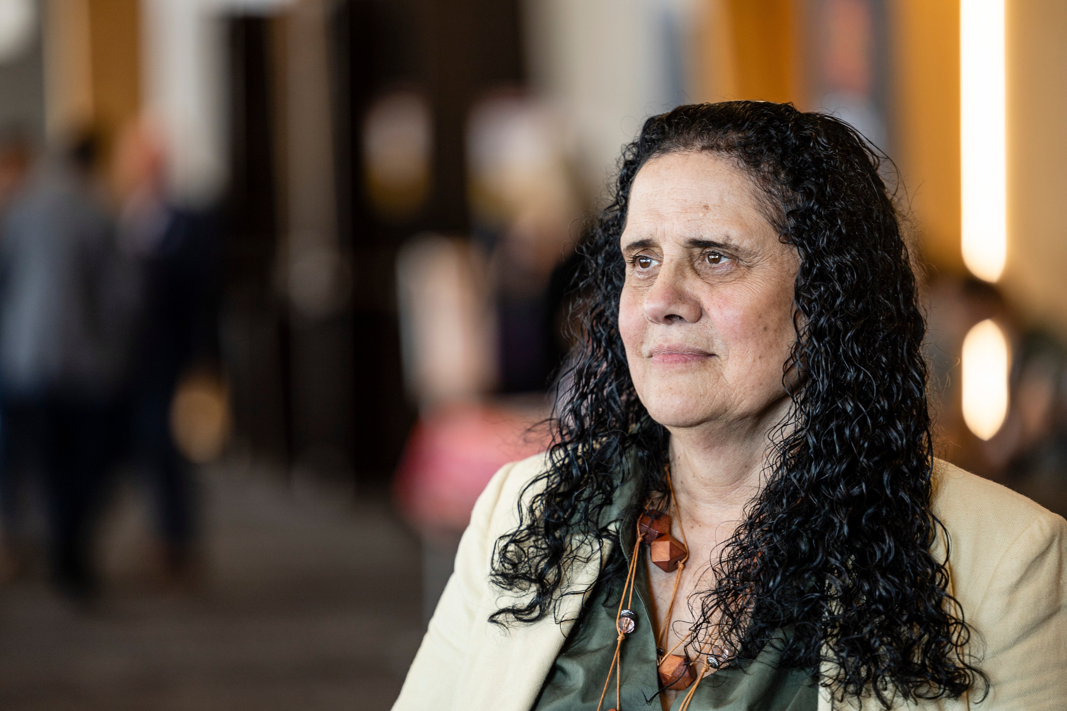 Portrait photo of woman with black curly wearing white blouse