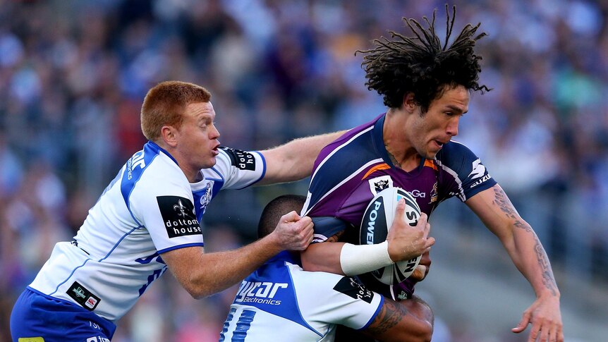 Kevin Proctor of the Storm is tackled during the 2012 NRL grand final.