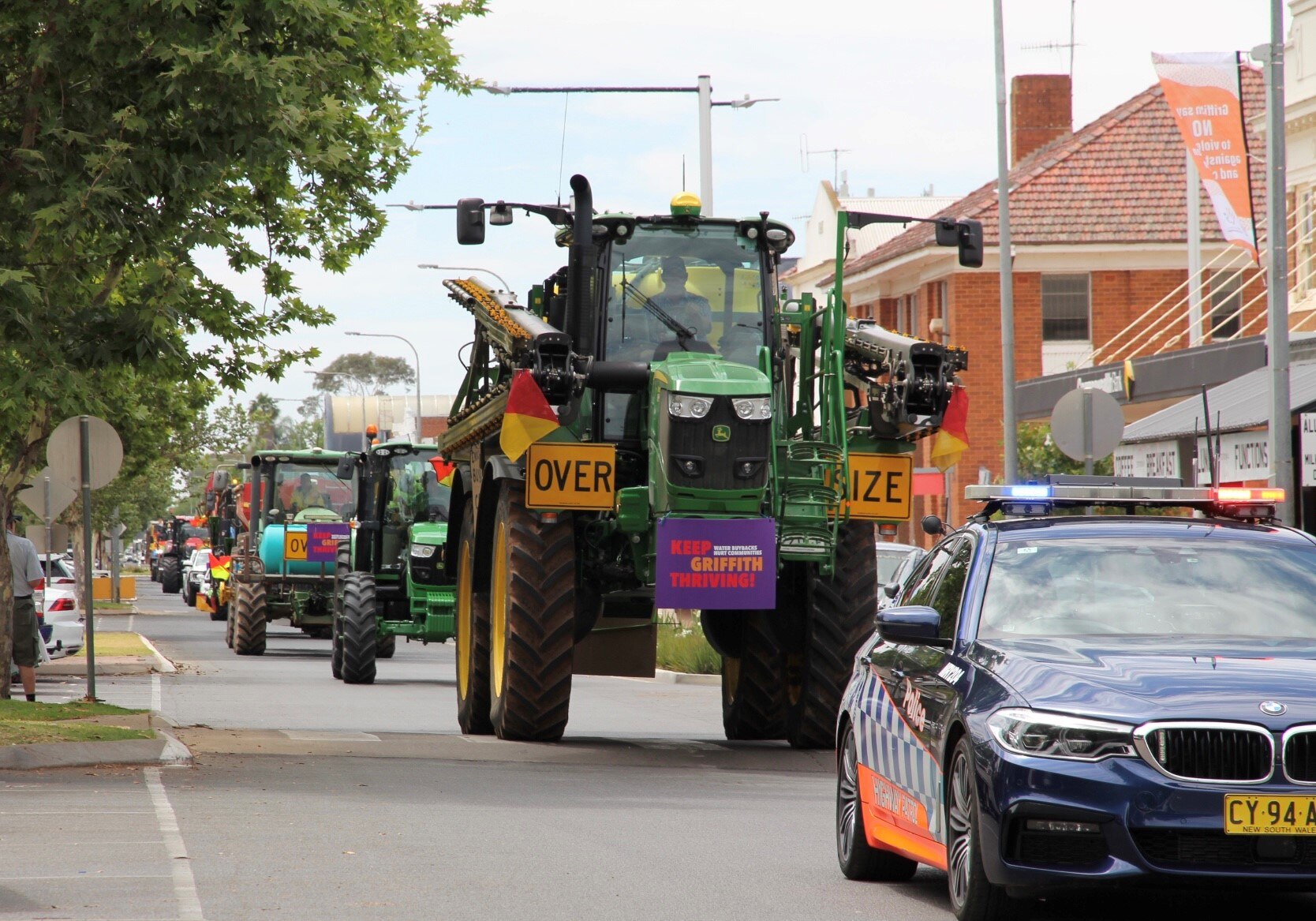 A big green tractor with protest banner