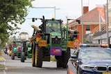 A big green tractor with protest banner
