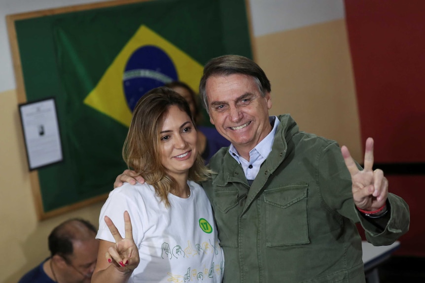 Brazil president-elect Jair Bolsonaro poses with his wife before voting.