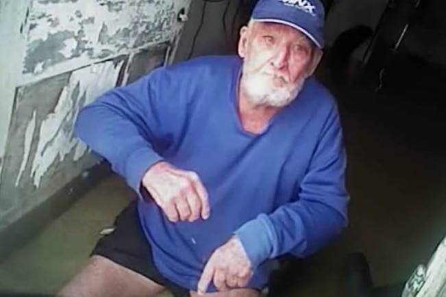 Des Smith sits in a mobility chair in floodwaters that swamped his house near Richmond.