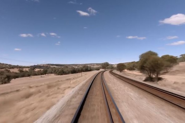 The view from the front of the Indian Pacific train, showing train tracks and the sky