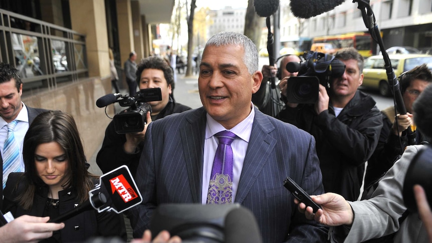 Gangland figure Mick Gatto leaves the Melbourne Magistrates Court, surrounded by media.