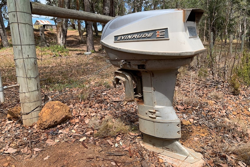 A mailbox made from an outboard motor next to a fence at a rural property in Denmark, Western Australia.