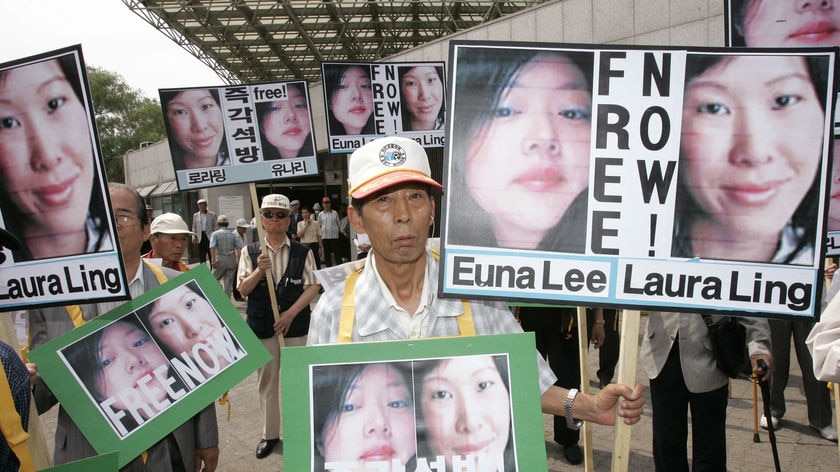 Conservative protesters hold portraits of US journalists Euna Lee (L) and Laura Ling