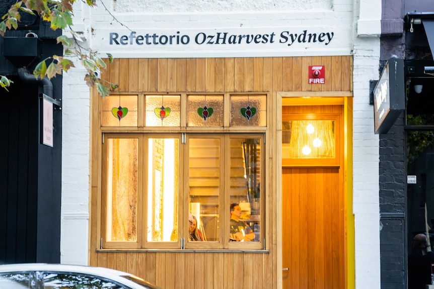 The outside of a restaurant with a wooden door and window frames