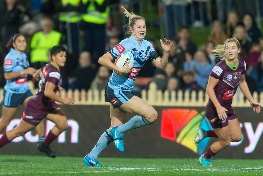 Kezie Apps runs away from the Queensland defence in the women's State of Origin match.