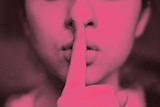 Close up of woman using her finger to express a whisper illustrating ASMR (Autonomous sensory meridian response) culture.