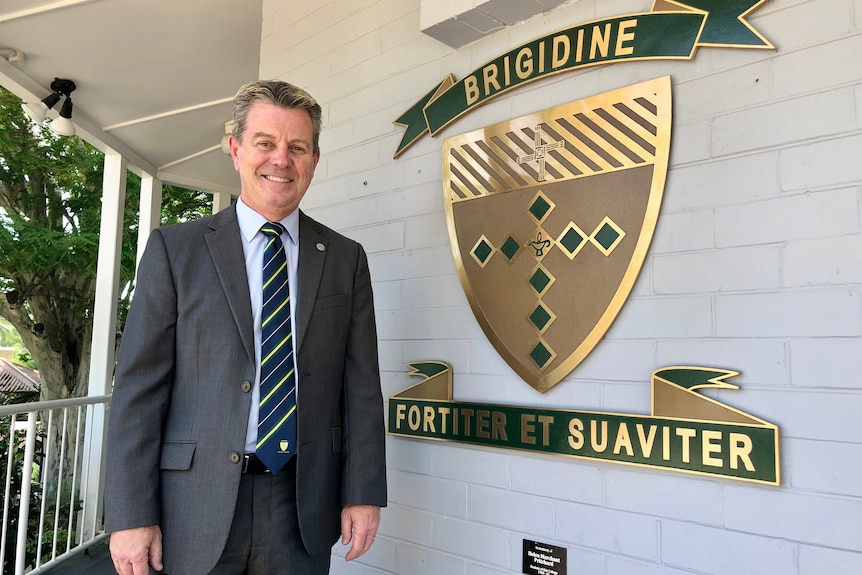 A man next to the Brigidine College sign