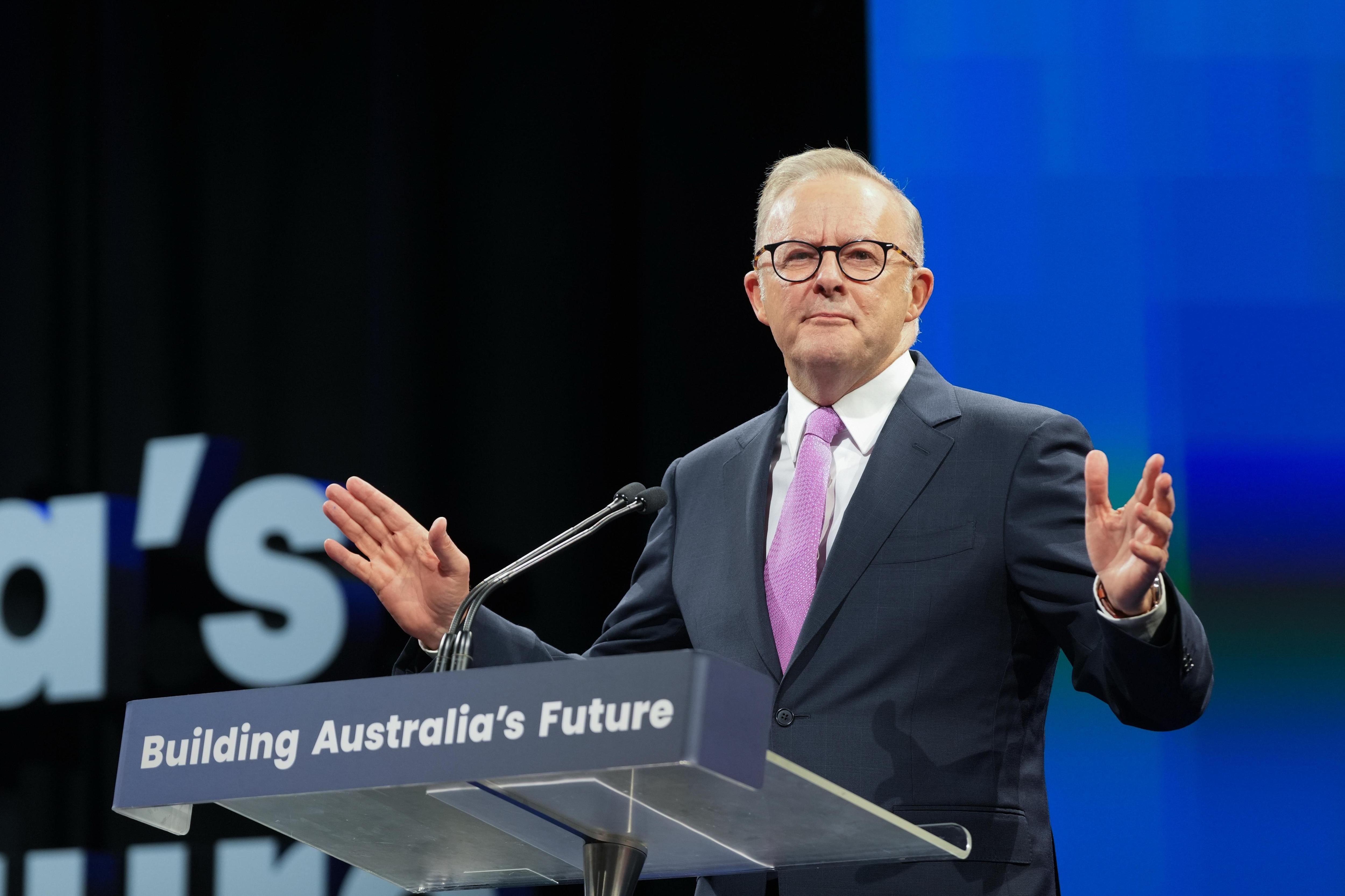 一位身着西装的男性政客在讲台上发表演讲