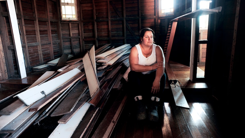 woman wearing a white singlet in empty room with timber pieces