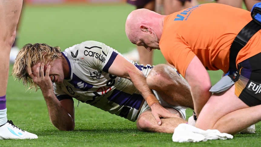 A man looks distressed after breaking his ankle in a rugby league match