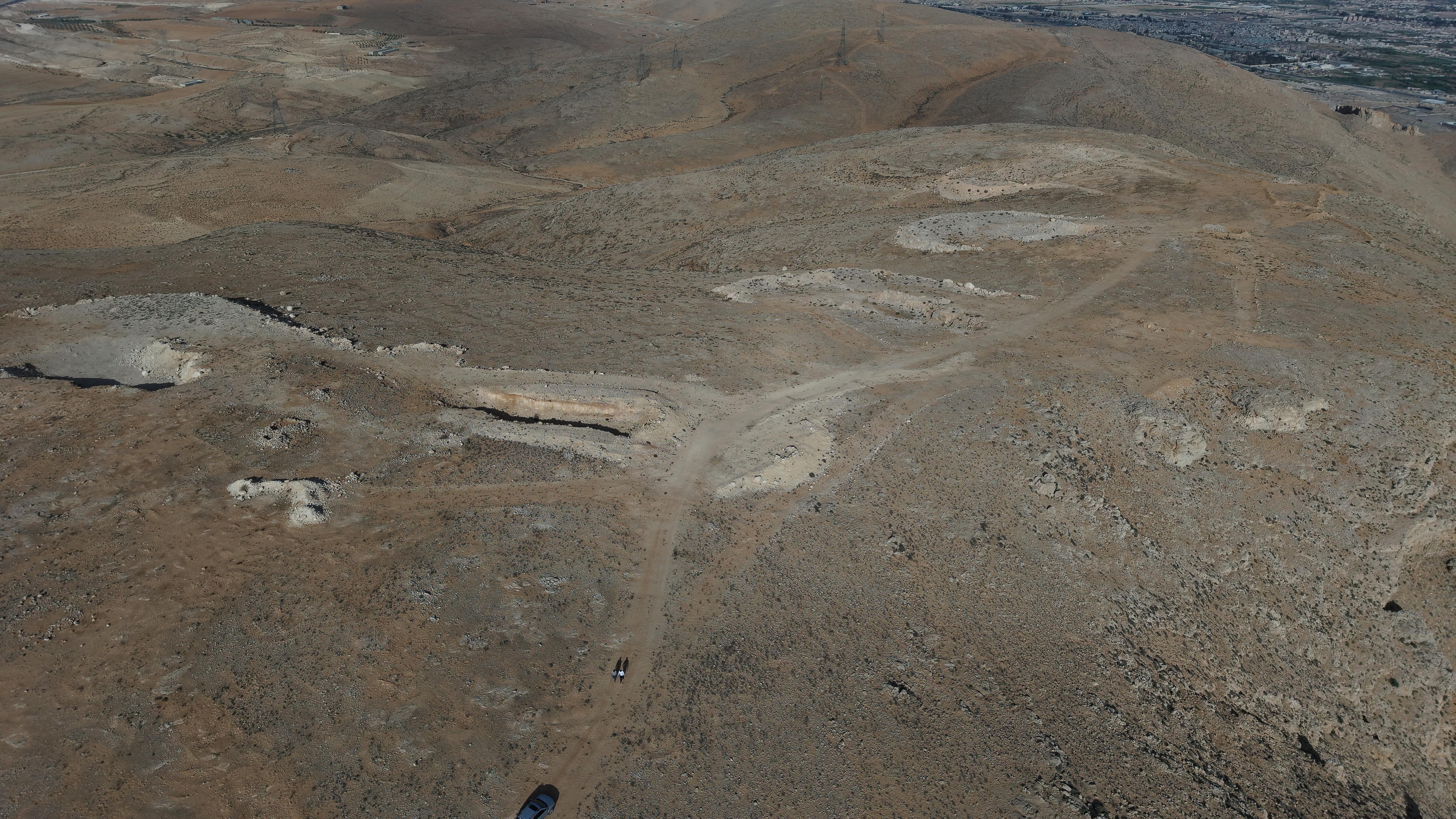 Aerial view of a mass grave in a vast landscape. 