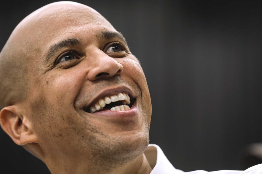 Cory Booker smiles looking off to the side of the photo
