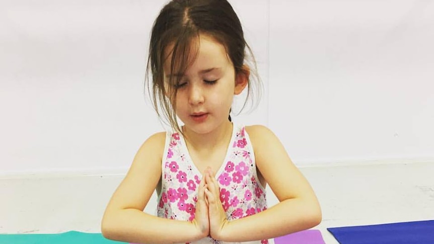 A child in a restful yoga pose