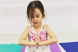 Child in peaceful yoga pose
