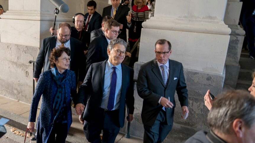 Al Franken holds hands with his wife Franni Bryson as he leaves the Capitol.