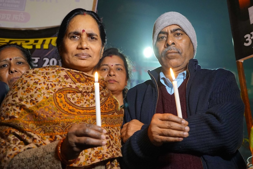 An Indian woman in a sari holding a candle