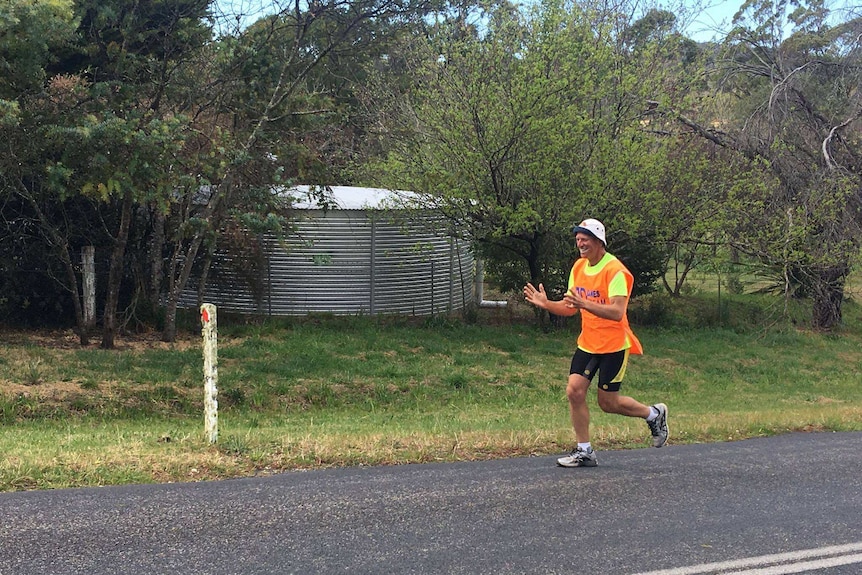 Dane Waites in his fluoro top running along a highway