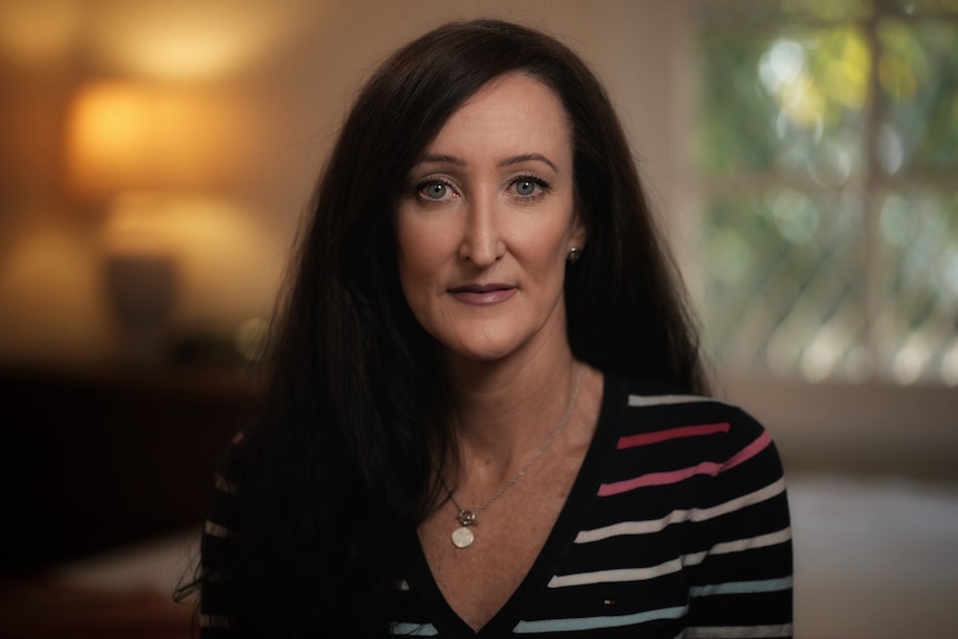 A portrait of a woman with dark hair and a somber expression. 