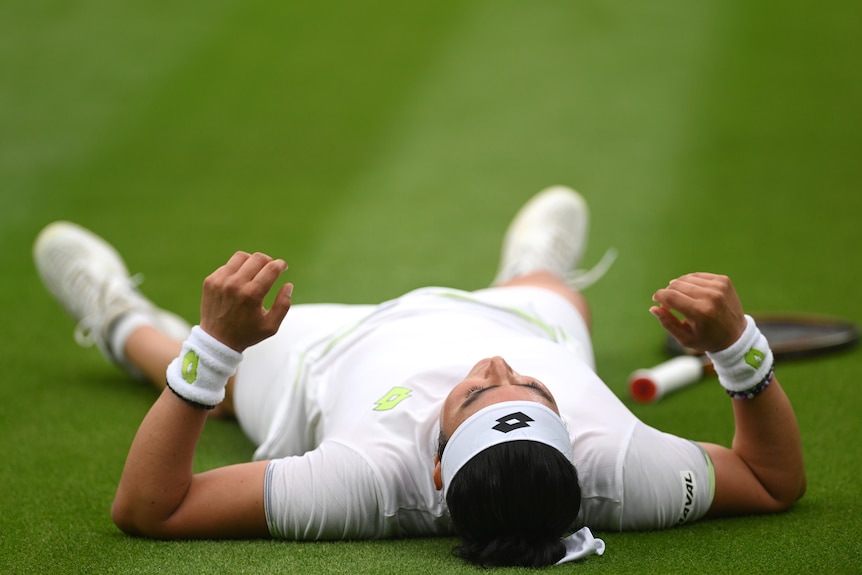 Ons Jabeur of Tunisia falls to the floor after winning match at Wimbledon. 