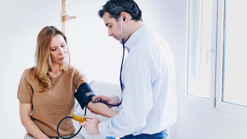 A doctor checks a patient's blood pressure