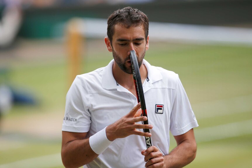 Marin Cilic holds his racquet to his face during his Wimbledon semi-final against Sam Querrey.