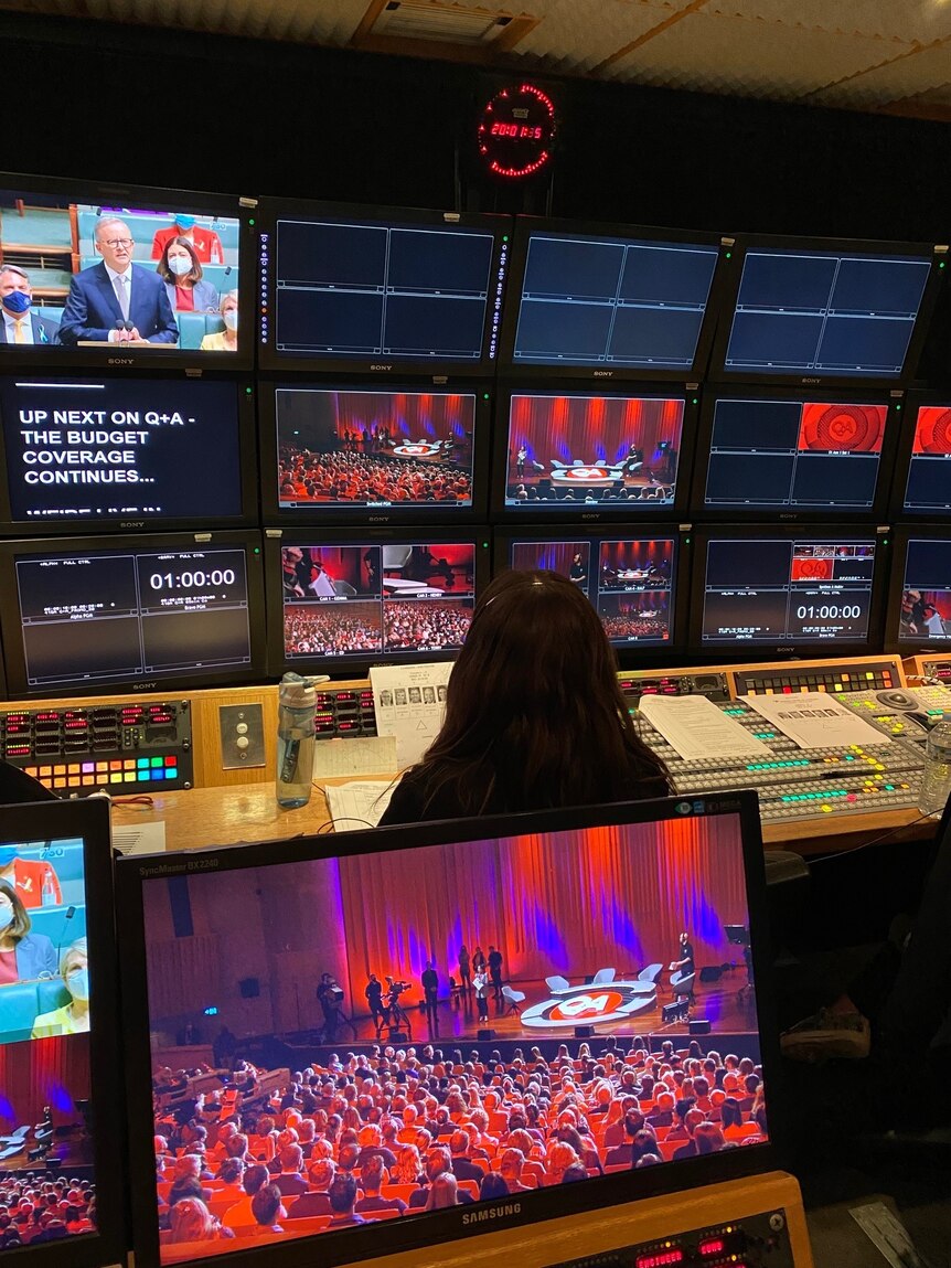 TV control room showing screens with Q+A program on air.