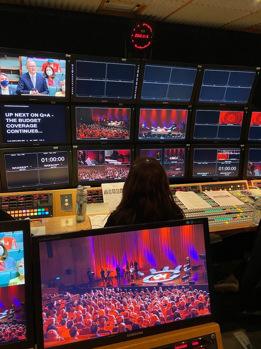 TV control room showing screens with Q+A program on air.