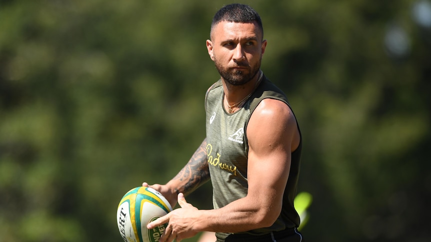 A Wallabies squad member looks to his left as he prepares to pass the ball at a training session.