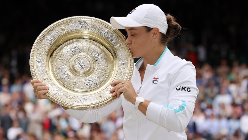 Australian tennis player Ash Barty kissing the Winbledon trophy after winning the tournament 