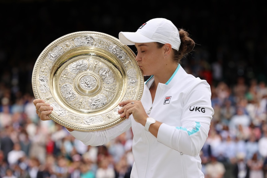 Australian tennis player Ash Barty kissing the Winbledon trophy after winning the tournament 