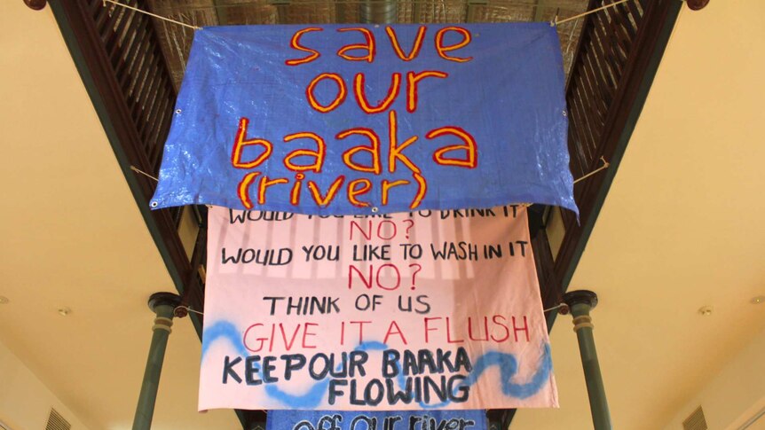 Banners reading "Save out Baaka" and "Would you like to wash in it? No. Think of us, give it a flush. Keep our Barka flowing".
