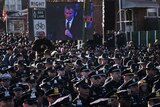 Law enforcement officers turn their backs on a live video monitor showing New York City Mayor Bill de Blasio at the funeral of slain New York Police Department (NYPD) officer Rafael Ramos, New York December 27, 2014