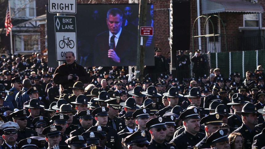Law enforcement officers turn their backs on a live video monitor showing New York City Mayor Bill de Blasio at the funeral of slain New York Police Department (NYPD) officer Rafael Ramos, New York December 27, 2014