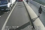 A still from CCTV footage showing a woman walking across a bridge with a jogger running towards her.